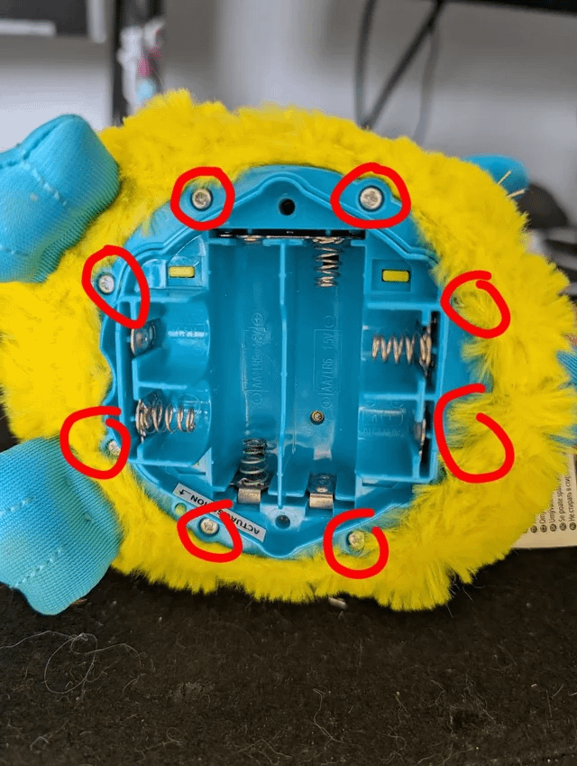 Eight fur screws marked on the Furby battery area