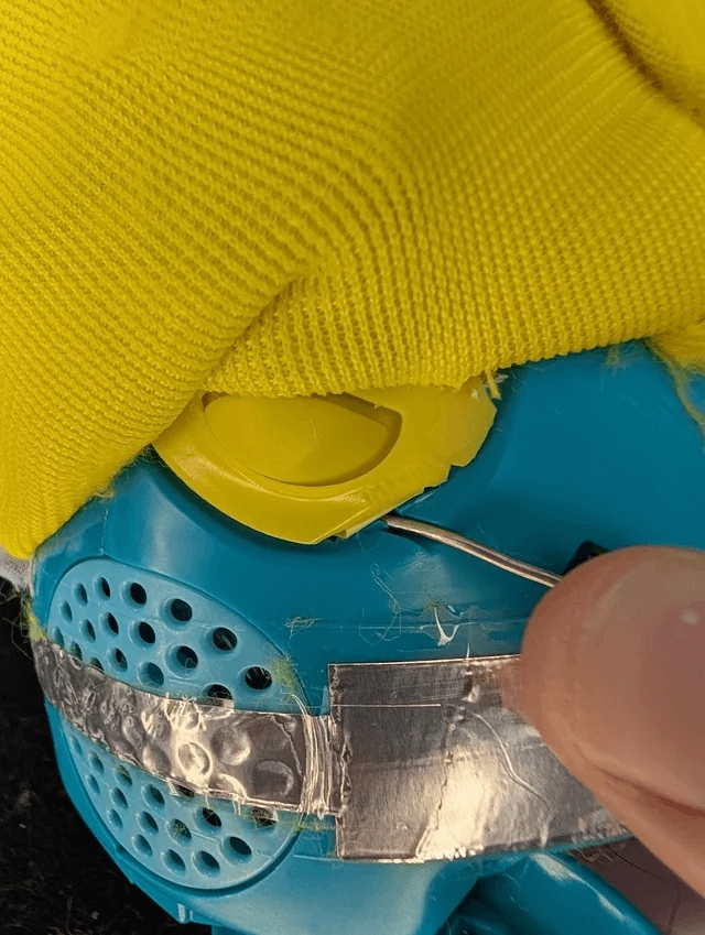 Plastic ear tabs under Furby fur