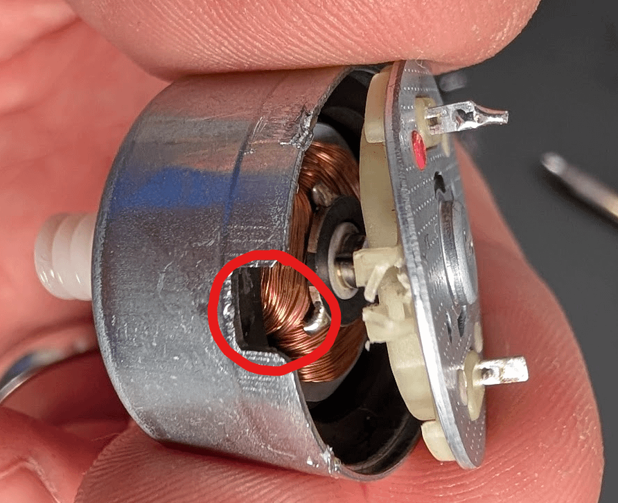 Small hole used to pry the motor bottom plate open